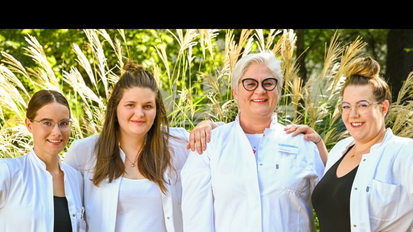 Gruppenfoto Zentrum für lysosomale Speichererkrankungen mit vier Frauen in weißen Kitteln vor Pampas-Gras-Büscheln